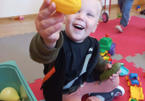 chłopiec bawi się warzywami